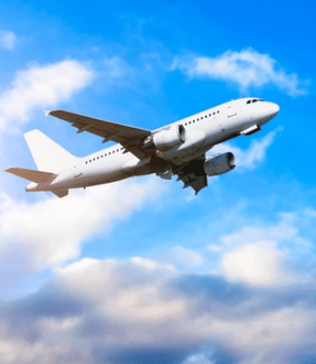 Picture of airplane flying through a blue sky with clouds